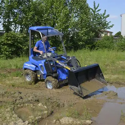 Pienkuormaaja MultiOne 2.3 ajaa mudassa.