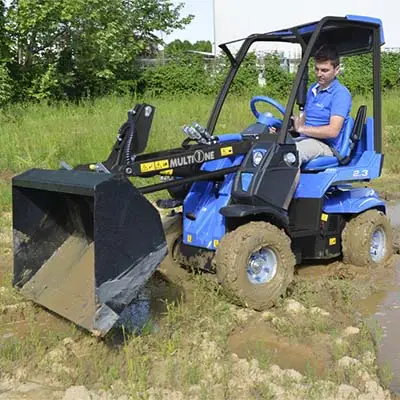 Pienkuormaaja MultiOne 2.3 kauhalla mudassa.