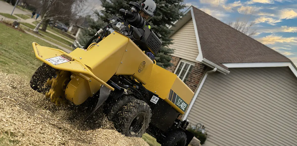 Kantojyrsin Vermeer SC402 jyrsimässä kantoja talon edessä.